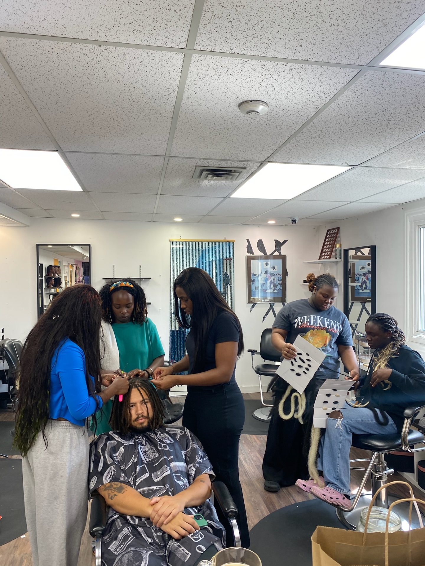 Students braiding a client in the Hairbru studio